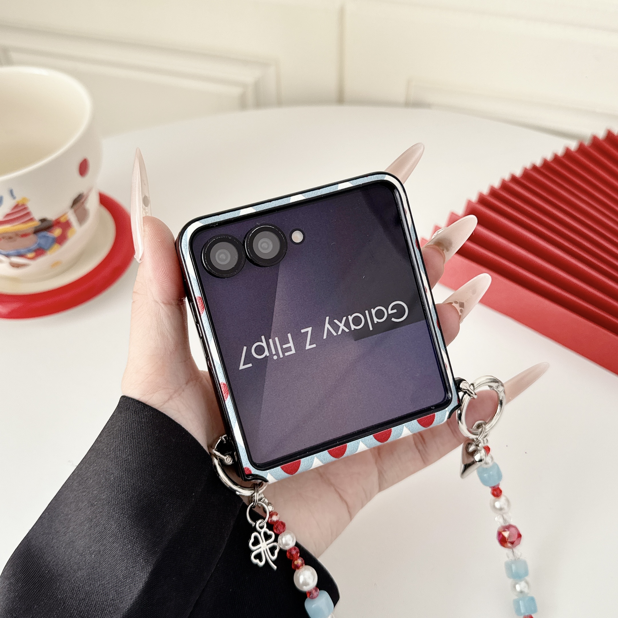 Samsung Galaxy Z Flip 7 slim phone case, featuring a detachable magnetic heart-shaped stand and a beaded hand strap. - Image 9