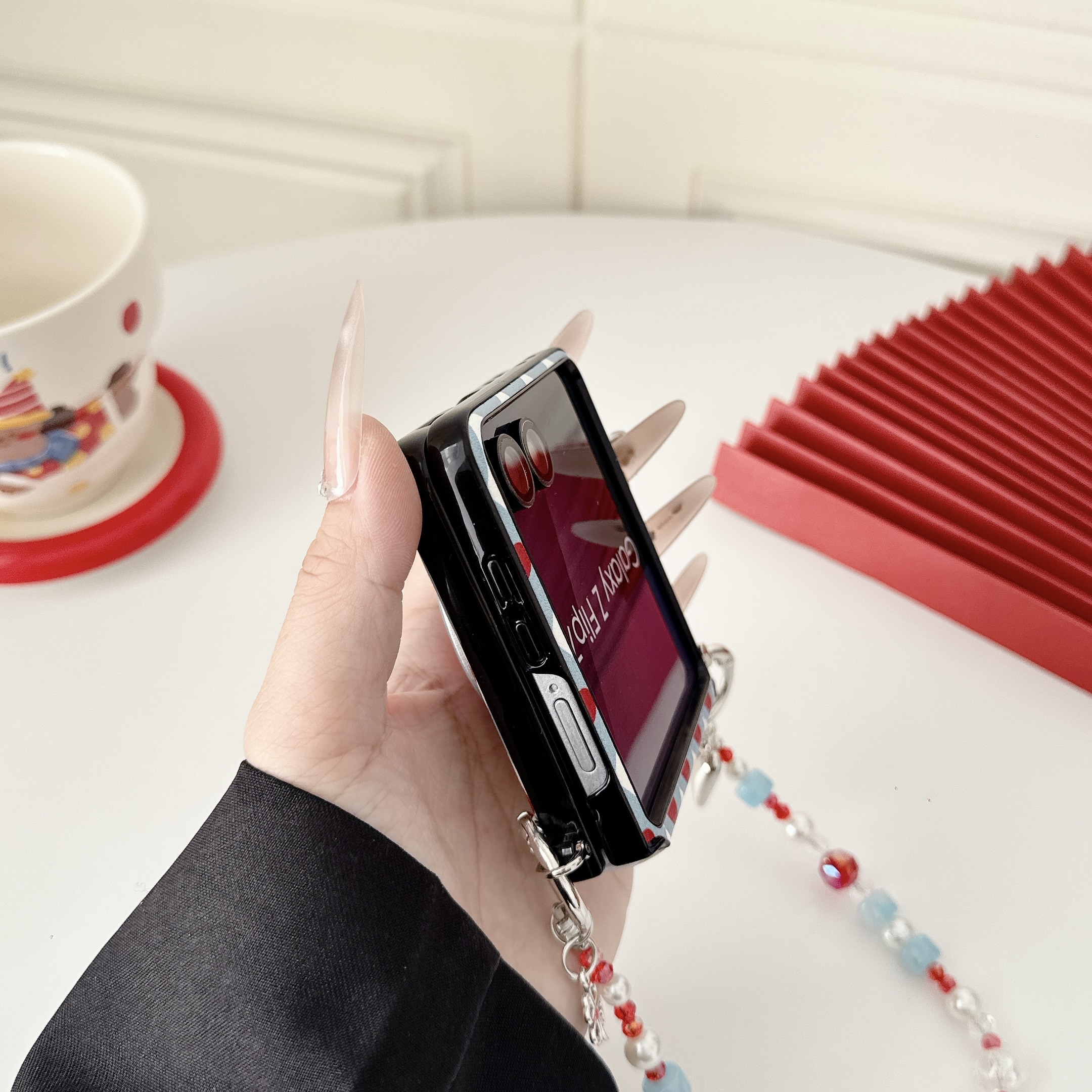 Samsung Galaxy Z Flip 7 slim phone case, featuring a detachable magnetic heart-shaped stand and a beaded hand strap. - Image 8