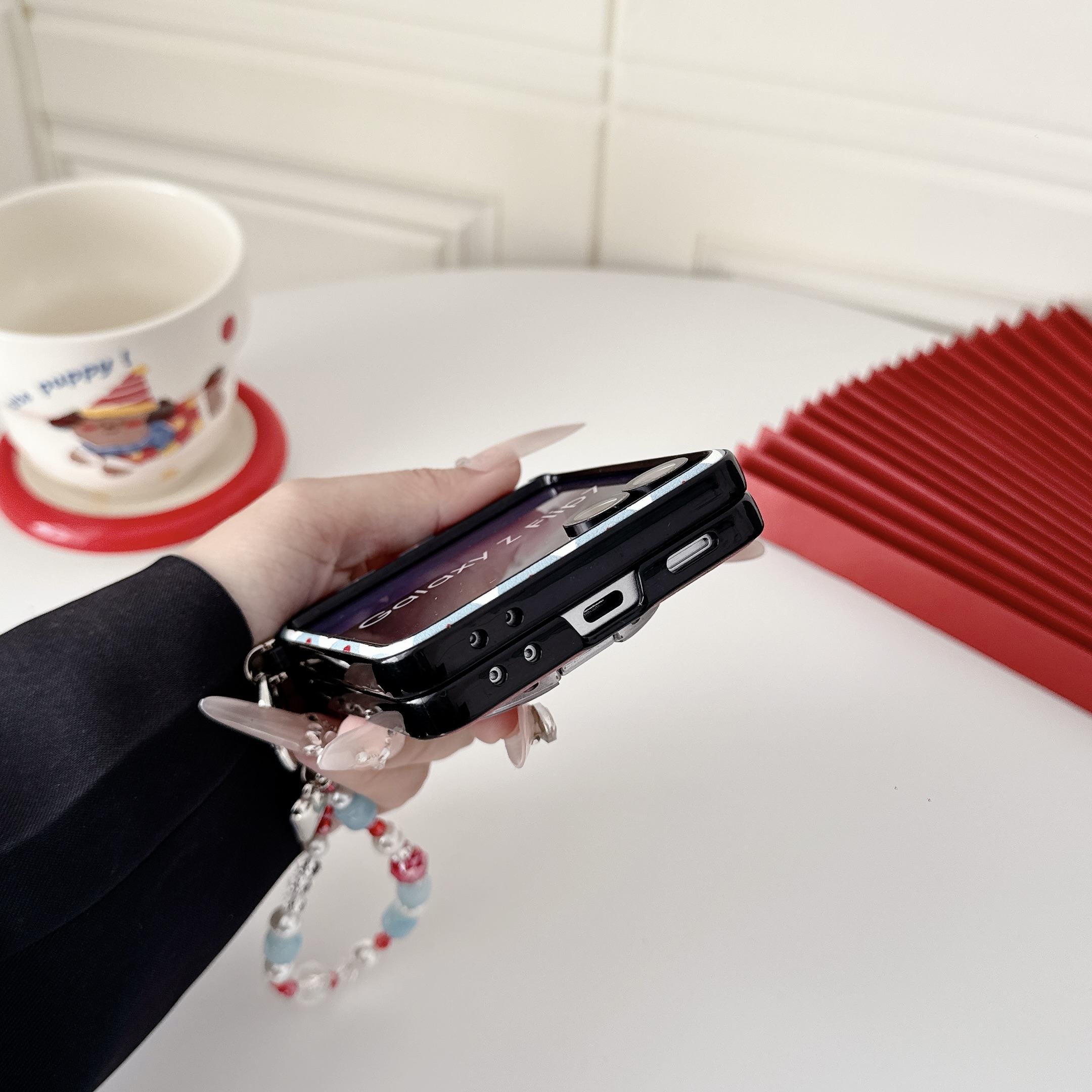 Samsung Galaxy Z Flip 7 slim phone case, featuring a detachable magnetic heart-shaped stand and a beaded hand strap. - Image 6